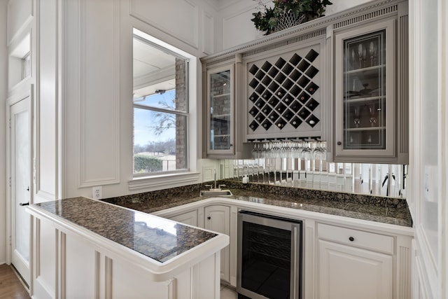 bar with wine cooler, backsplash, and wet bar