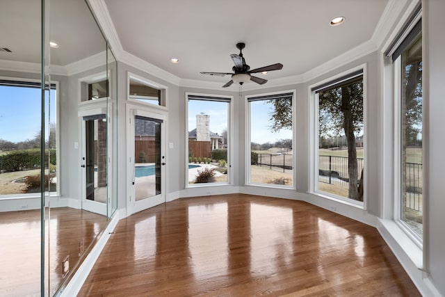 unfurnished sunroom with ceiling fan, visible vents, and a wealth of natural light