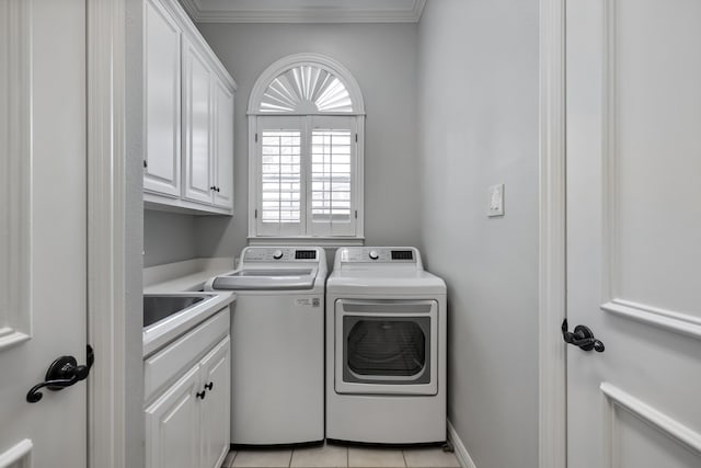 washroom with washing machine and clothes dryer, cabinet space, ornamental molding, light tile patterned flooring, and a sink