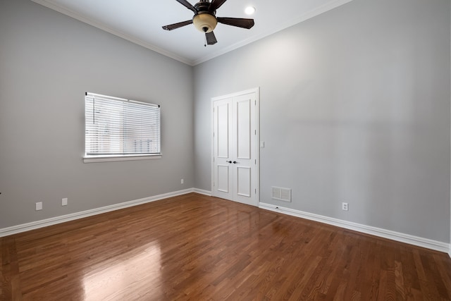 empty room featuring wood finished floors, visible vents, and baseboards