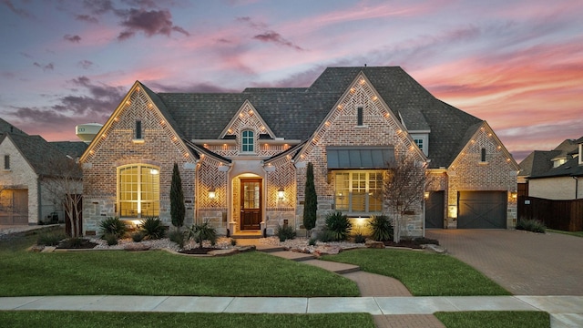 view of front facade featuring stone siding, brick siding, and decorative driveway