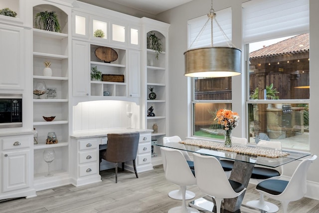 home office with light wood-type flooring and built in desk