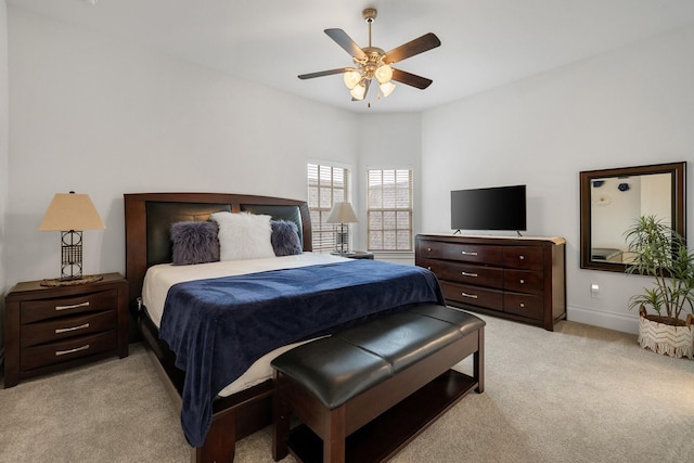 bedroom with light carpet, a ceiling fan, and baseboards