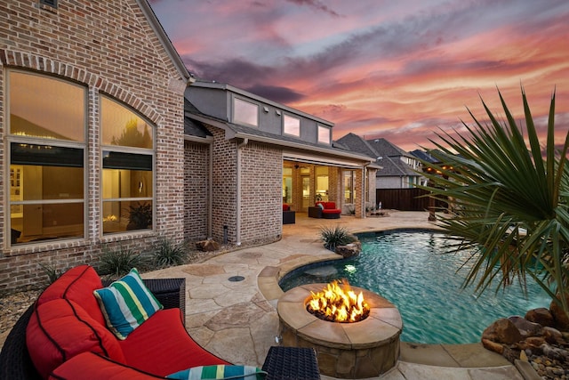 view of swimming pool with an outdoor fire pit, fence, a fenced in pool, and a patio