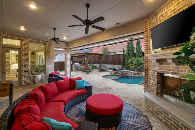 view of patio with ceiling fan, an in ground hot tub, an outdoor living space with a fireplace, and a fenced backyard