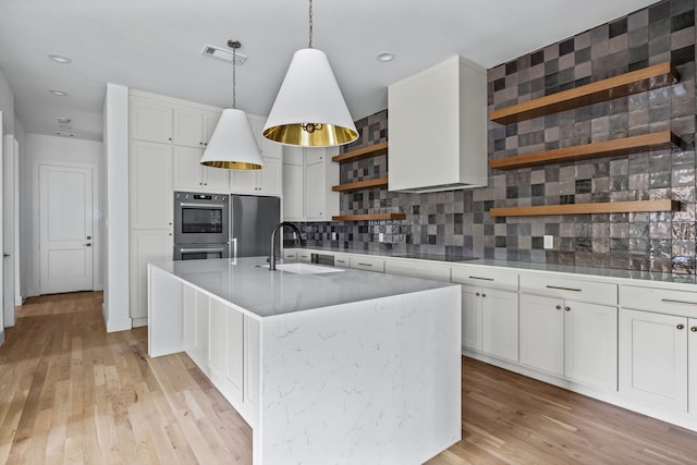 kitchen with visible vents, refrigerator, black electric stovetop, open shelves, and a sink