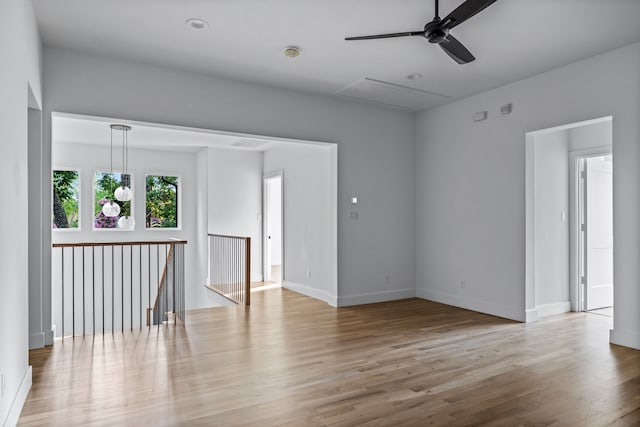 unfurnished room featuring a ceiling fan, baseboards, and wood finished floors