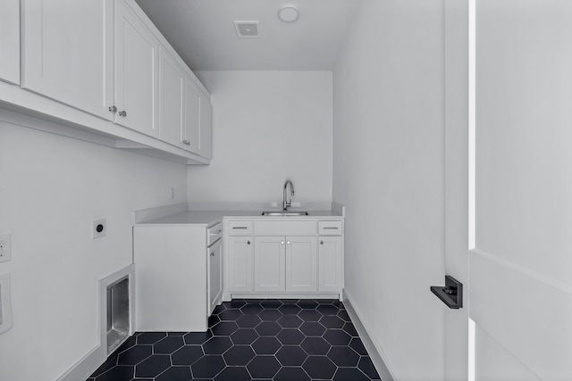 washroom with cabinet space, visible vents, a sink, electric dryer hookup, and baseboards