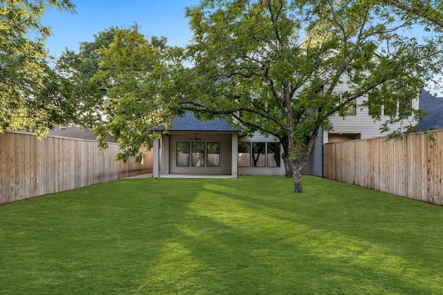 view of yard with ceiling fan and a fenced backyard