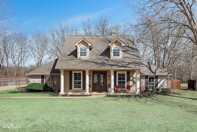 cape cod house featuring brick siding, roof with shingles, a front yard, and fence