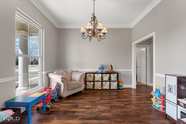 sitting room with crown molding, a notable chandelier, plenty of natural light, and wood finished floors