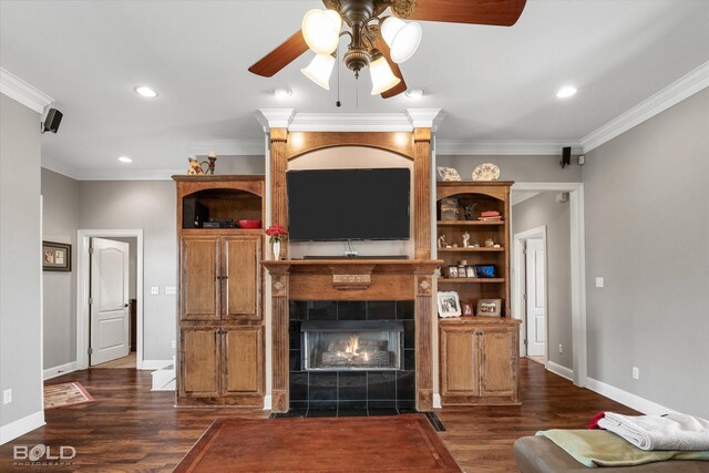 unfurnished living room with crown molding, recessed lighting, a tiled fireplace, dark wood-type flooring, and baseboards