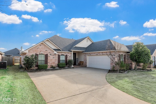 ranch-style home featuring an attached garage, central AC, brick siding, concrete driveway, and a front yard