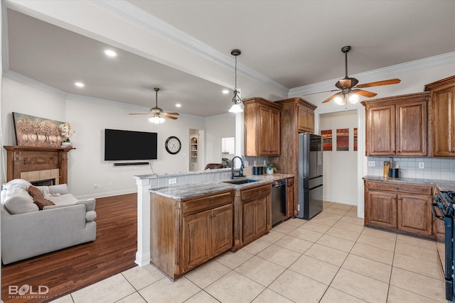 kitchen featuring dishwashing machine, a peninsula, a sink, open floor plan, and freestanding refrigerator