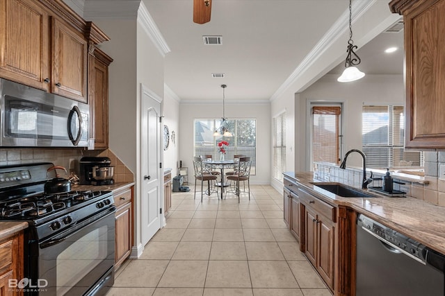 kitchen with visible vents, appliances with stainless steel finishes, brown cabinets, and a sink