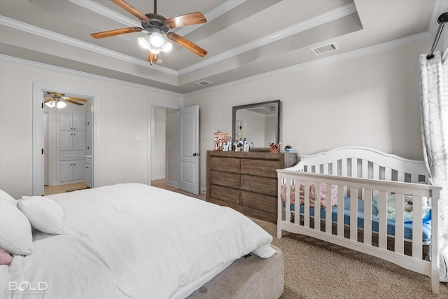 carpeted bedroom featuring ornamental molding, a raised ceiling, and visible vents