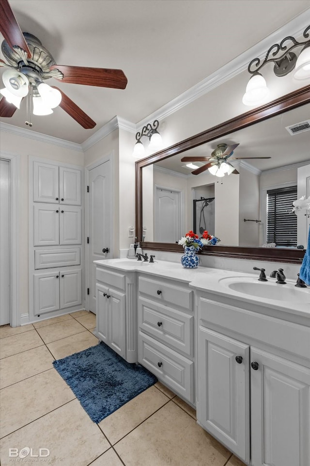 bathroom featuring tile patterned flooring, crown molding, visible vents, and a sink