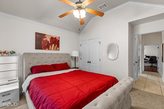 carpeted bedroom featuring crown molding, a closet, visible vents, vaulted ceiling, and tile patterned floors