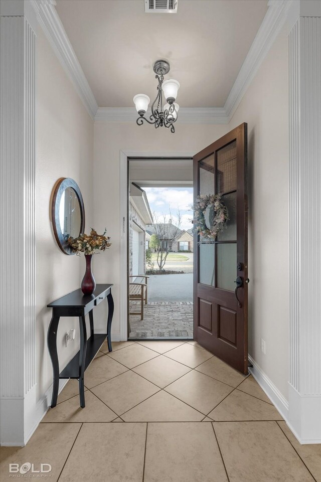 entrance foyer featuring light tile patterned floors, a notable chandelier, visible vents, and crown molding