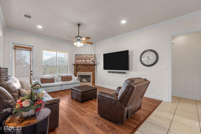 living area with ornamental molding, visible vents, and baseboards