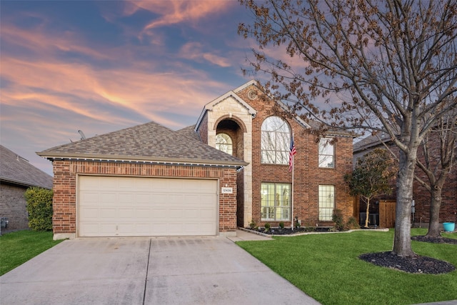 traditional home featuring brick siding, driveway, a front lawn, and a garage