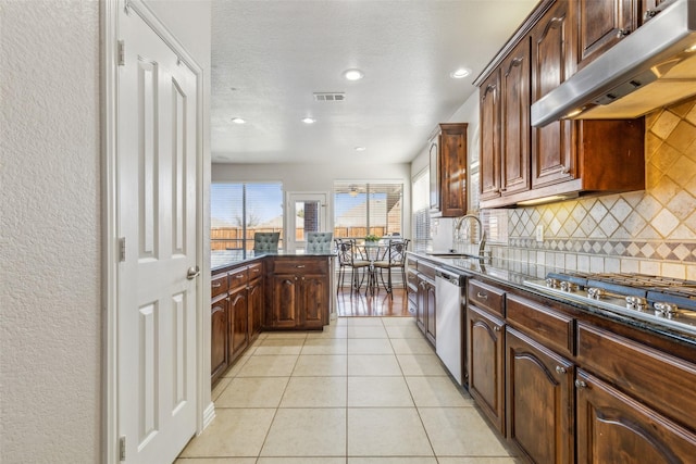 kitchen featuring under cabinet range hood, a sink, appliances with stainless steel finishes, light tile patterned flooring, and decorative backsplash