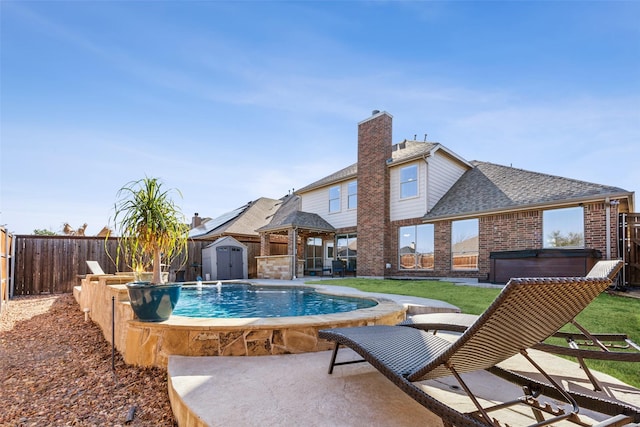 view of pool with an outbuilding, a fenced backyard, a hot tub, a storage unit, and a patio area