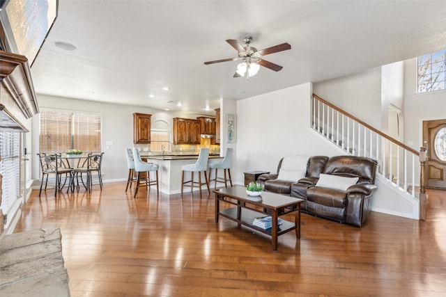 living area with hardwood / wood-style flooring, recessed lighting, baseboards, ceiling fan, and stairs