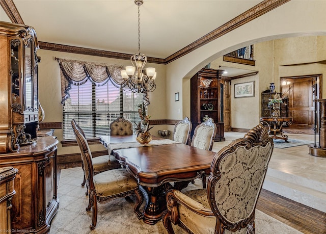 dining area featuring a chandelier, arched walkways, crown molding, and baseboards