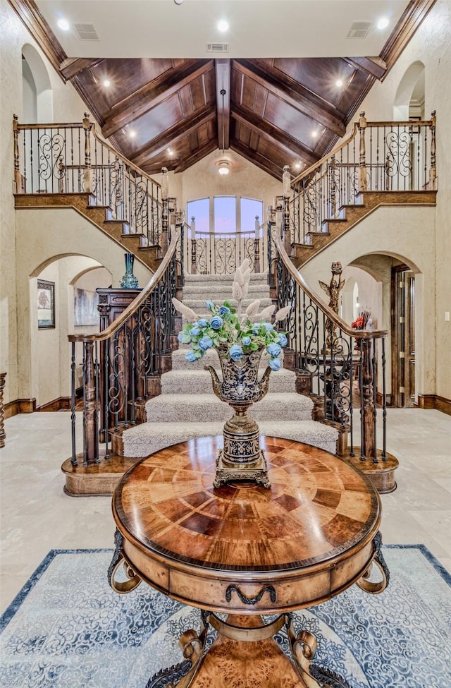 interior space featuring high vaulted ceiling, visible vents, arched walkways, and beam ceiling