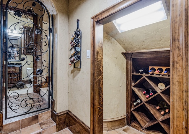 wine area with stone tile flooring and a textured wall