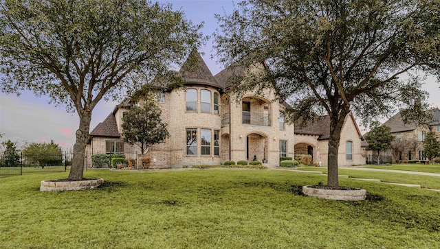 view of front of house with fence, a front lawn, and brick siding