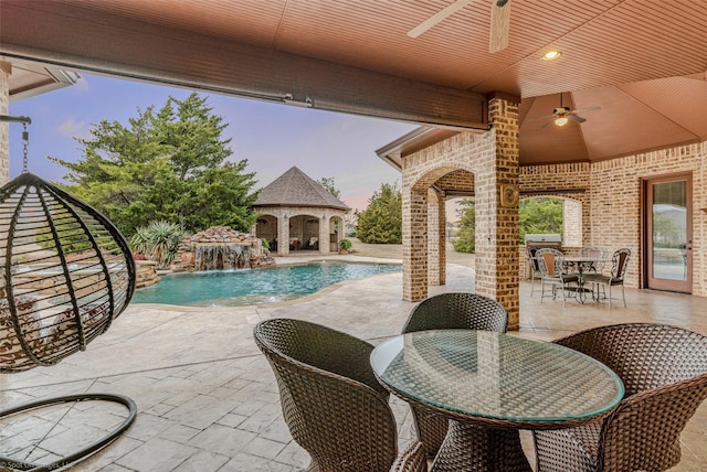 pool featuring a patio, ceiling fan, grilling area, an outbuilding, and outdoor dining area