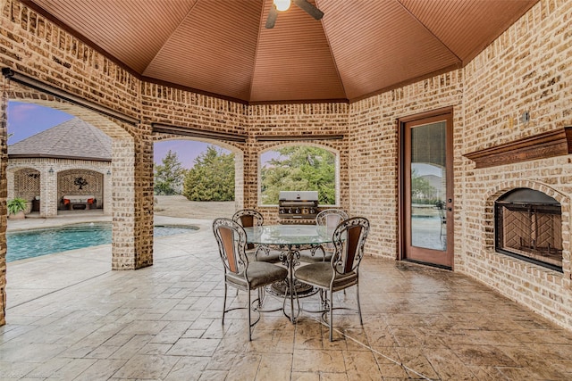 view of patio featuring an outdoor pool, an outdoor brick fireplace, grilling area, and outdoor dining space