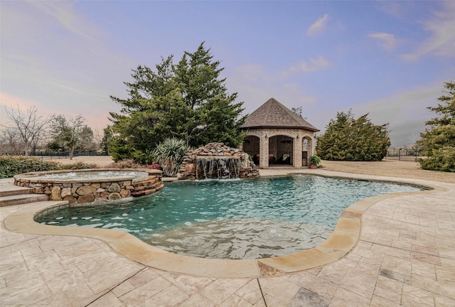 view of swimming pool featuring a pool with connected hot tub, a patio, and a gazebo