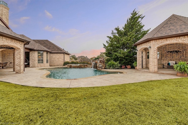 view of pool with a yard, a pool with connected hot tub, and a patio