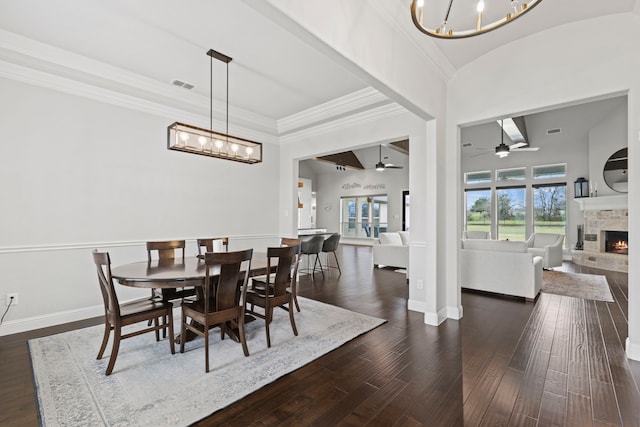 dining space featuring dark wood-type flooring, visible vents, a fireplace, and baseboards