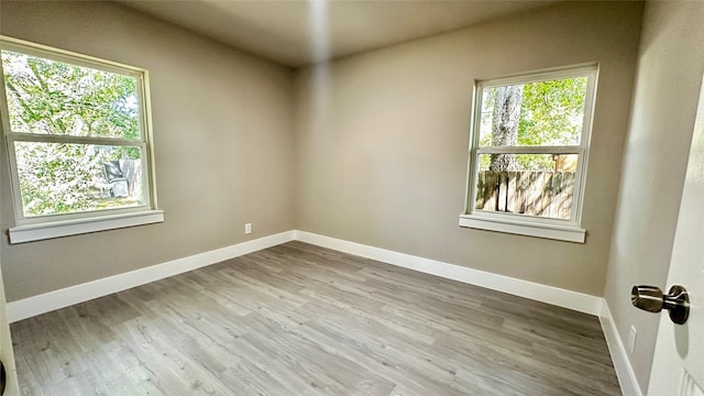 spare room with wood finished floors and baseboards