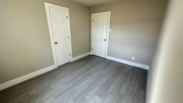 empty room featuring dark wood finished floors and baseboards