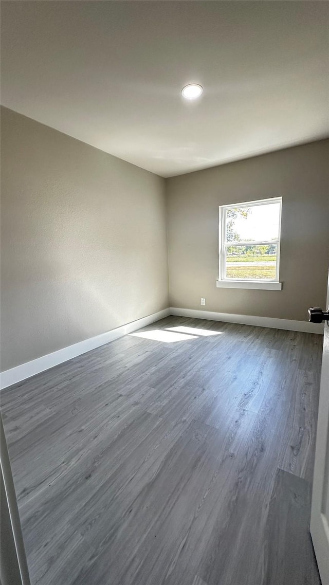 empty room with baseboards and wood finished floors