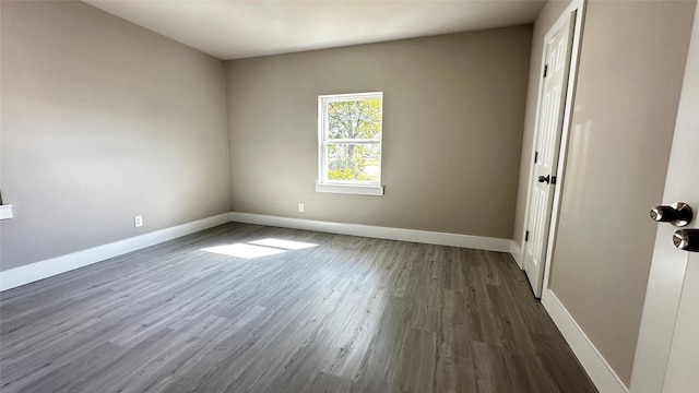 unfurnished room featuring dark wood finished floors and baseboards