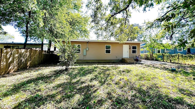 back of property with entry steps and fence