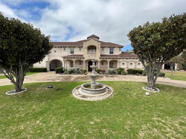 view of front of property with curved driveway and a front lawn