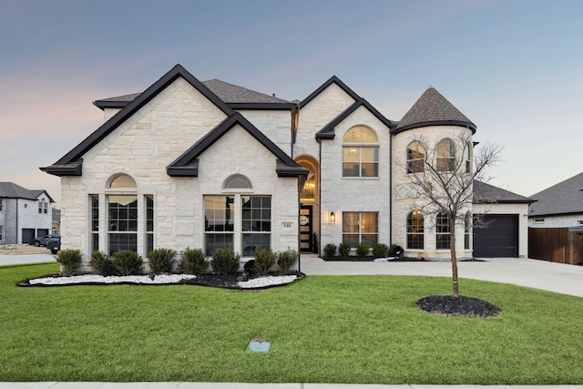 french country style house featuring driveway, roof with shingles, and a front yard