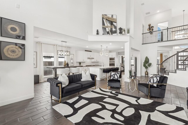 living area featuring a healthy amount of sunlight, wood tiled floor, and a notable chandelier