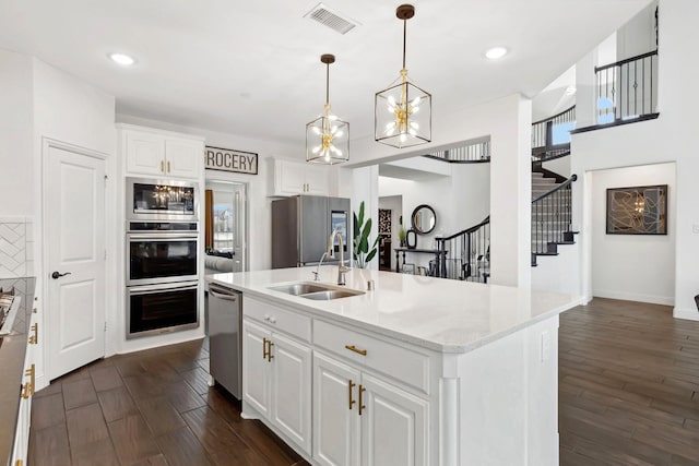 kitchen featuring visible vents, white cabinets, dark wood-style floors, appliances with stainless steel finishes, and a sink