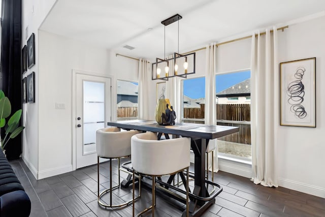 dining area with an inviting chandelier, visible vents, baseboards, and wood finish floors