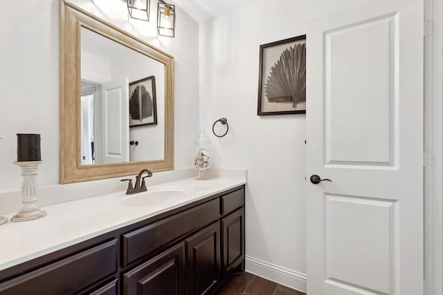 bathroom featuring wood finished floors, vanity, and baseboards