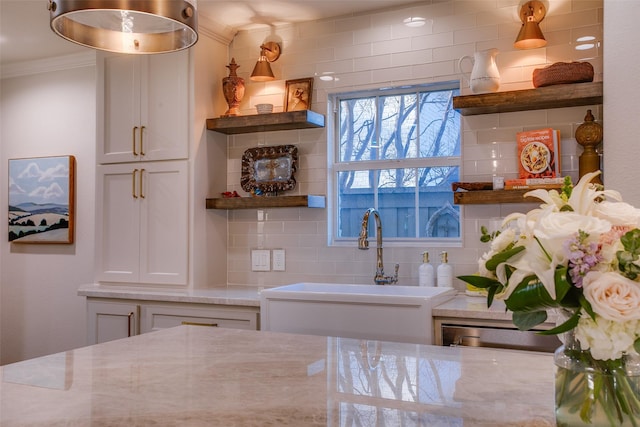 kitchen with tasteful backsplash, ornamental molding, open shelves, and a sink