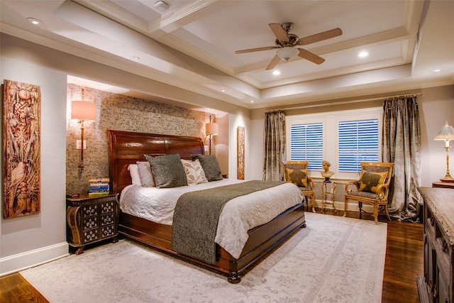 bedroom with crown molding, a tray ceiling, and wood finished floors